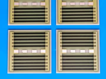 View 5: Controlled close crop of four AlN thick film heater samples showing printed paths and terminal-pad layouts