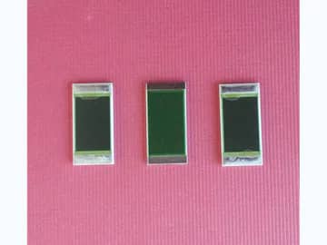 View 1: Three rectangular thick film power resistors with broad dark resistor films and silver-colored end terminals on a clean pink surface