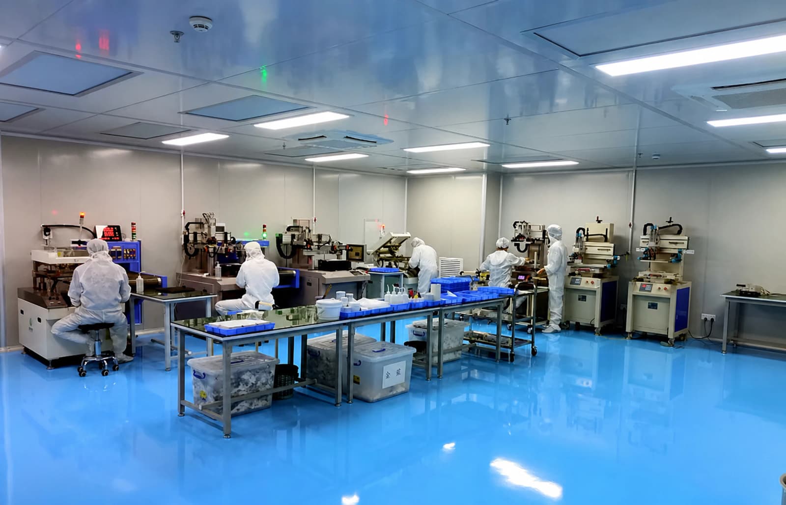 Company-presentation photograph of operators and screen-printing stations in the Dongguan production workshop