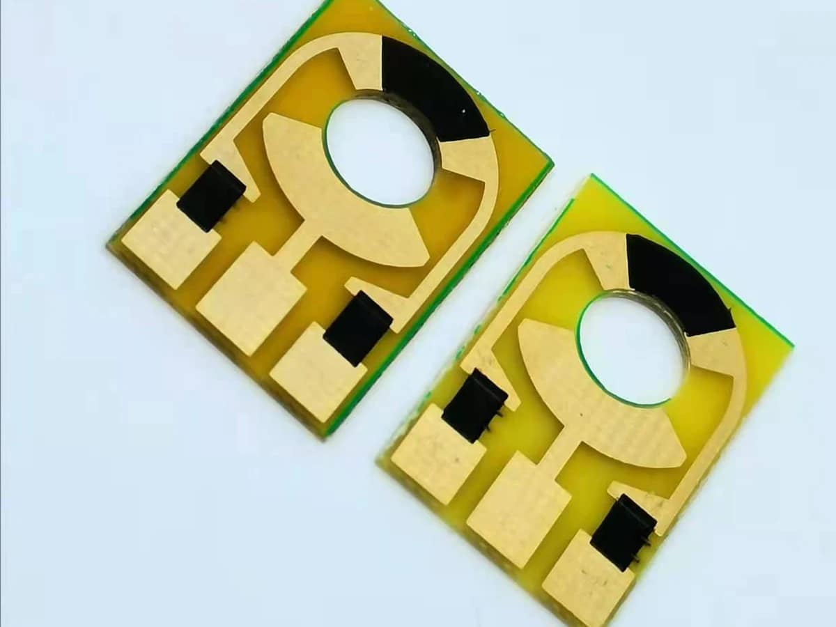 Controlled detail crop of a verified carbon contact PCB showing black contact material beside exposed conductor areas