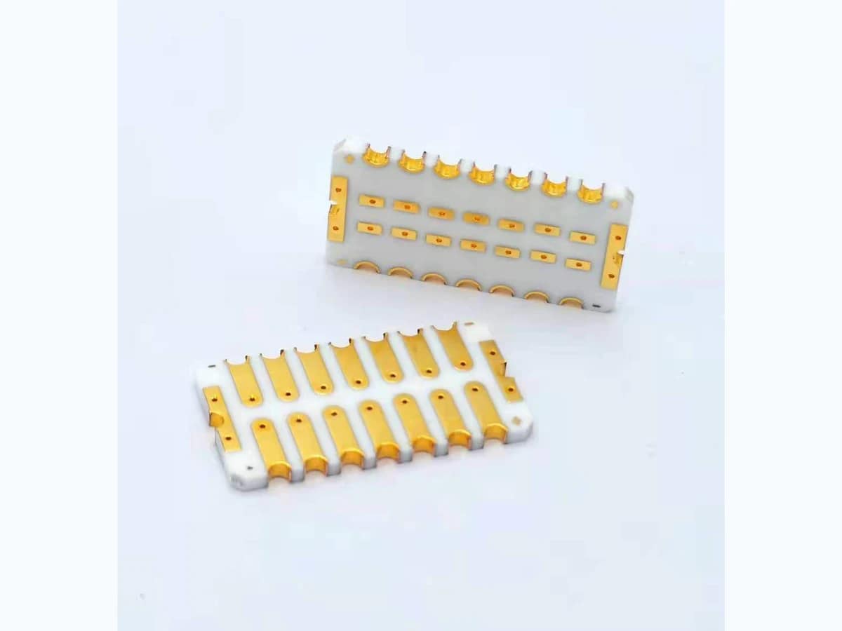Double-sided gold-colored ceramic PCBs with white ceramic bodies, patterned pads, holes, and scalloped edge features