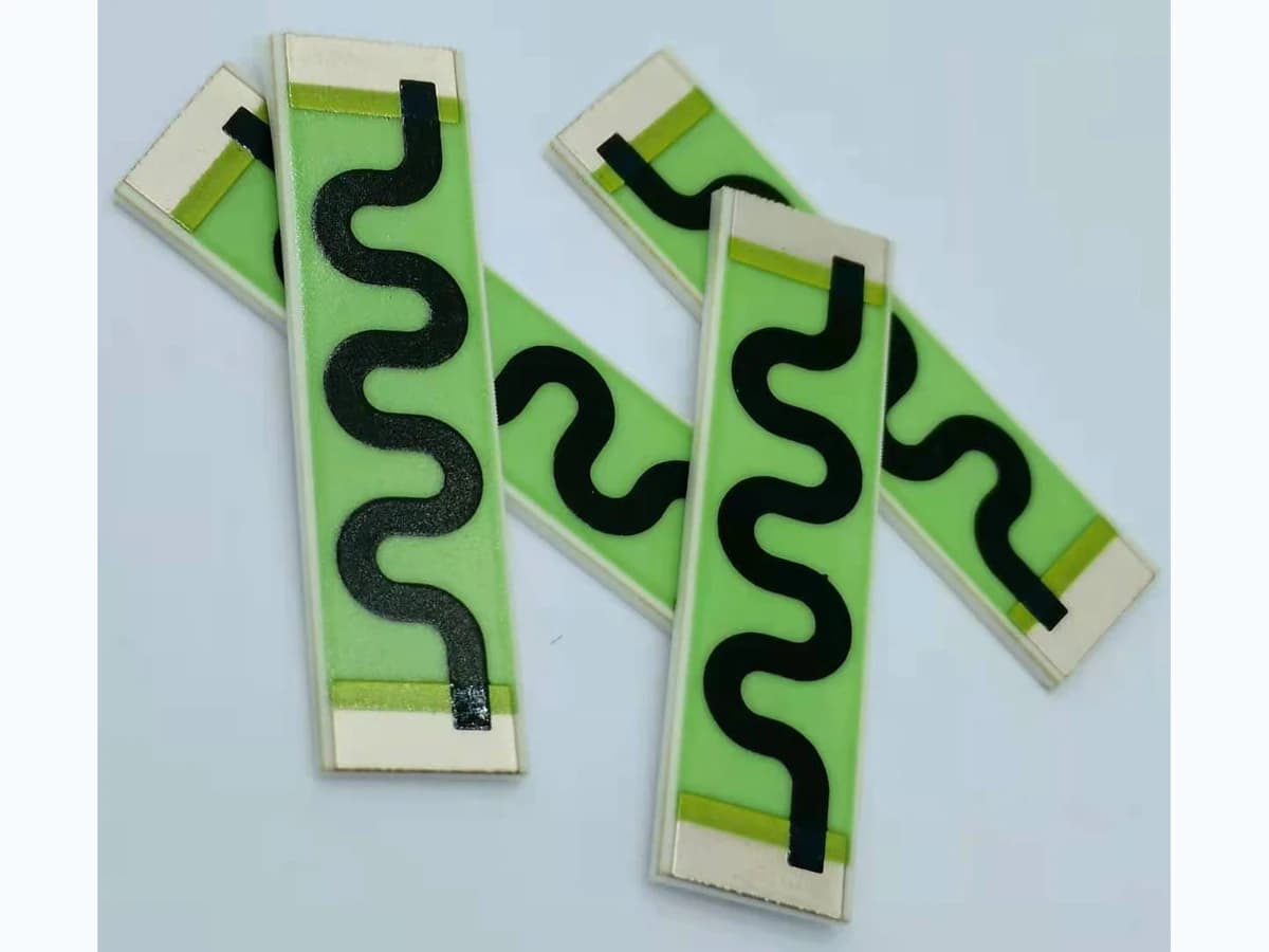 Real product photograph of elongated high-value printed resistors on ceramic substrates