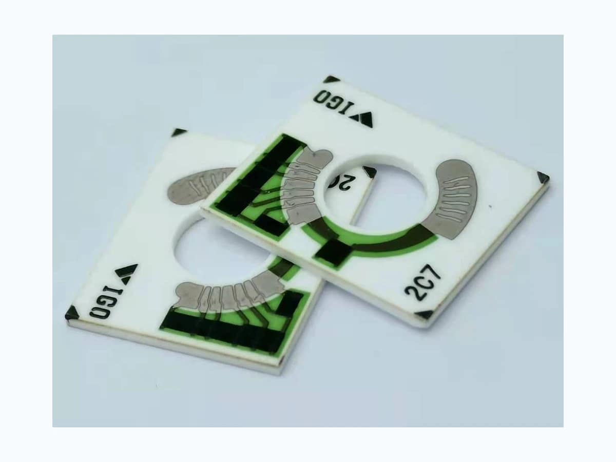 Two complete motorcycle fuel gauge resistor cards with central openings and arc tracks