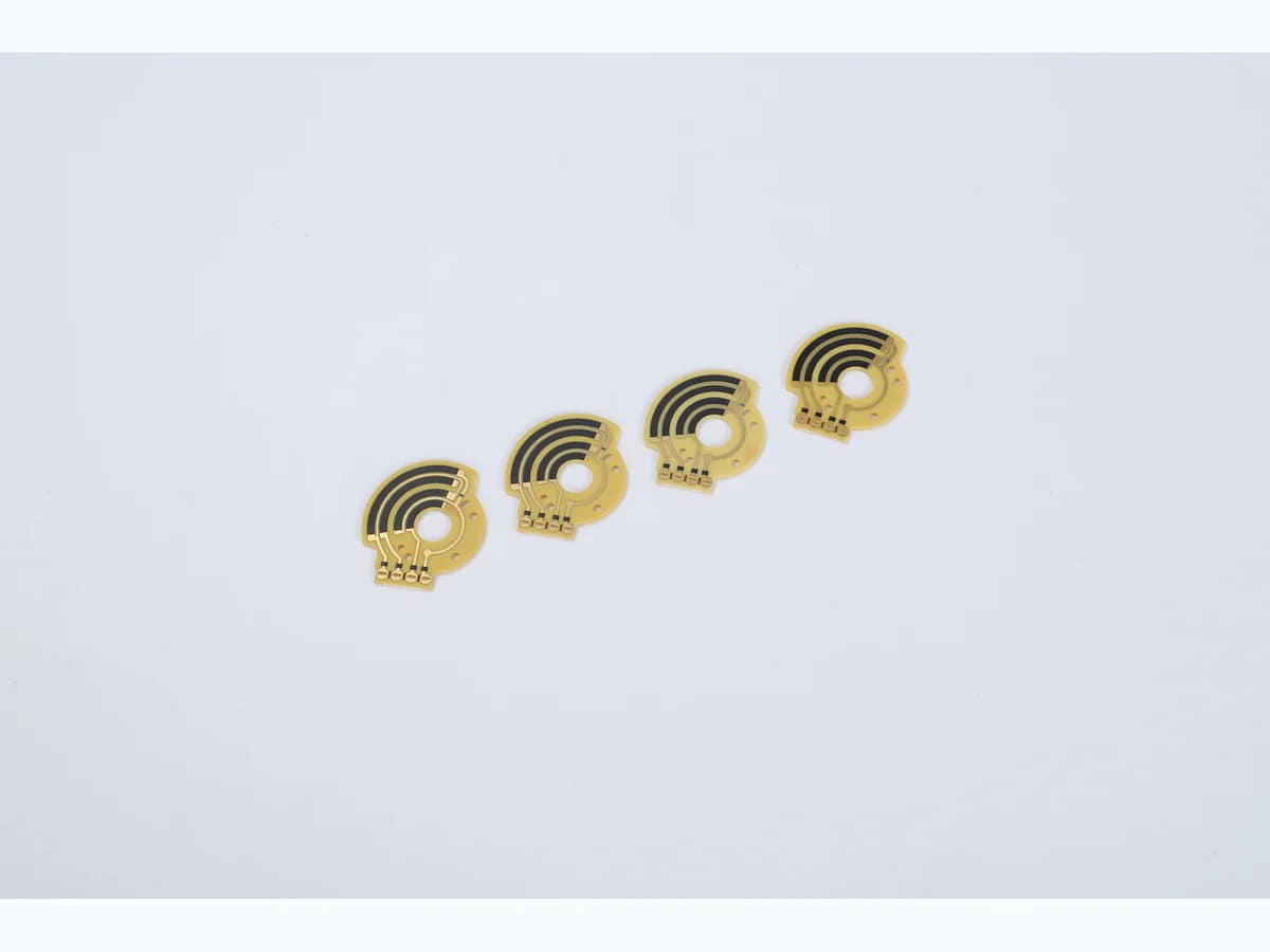 Four small rotary carbon film sensor PCBs with concentric black tracks and center openings