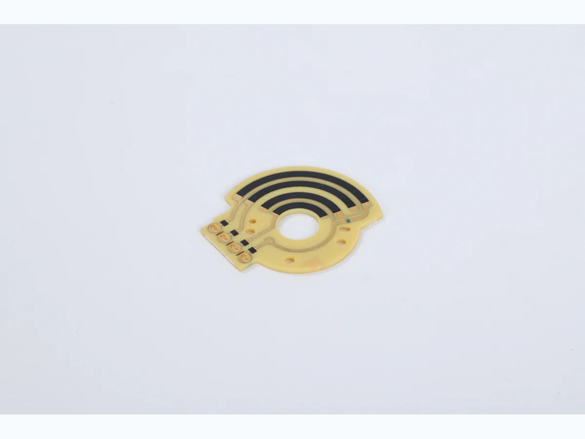 Real product photograph of a rotary polymer carbon-film sensor PCB showing arcuate tracks and terminals