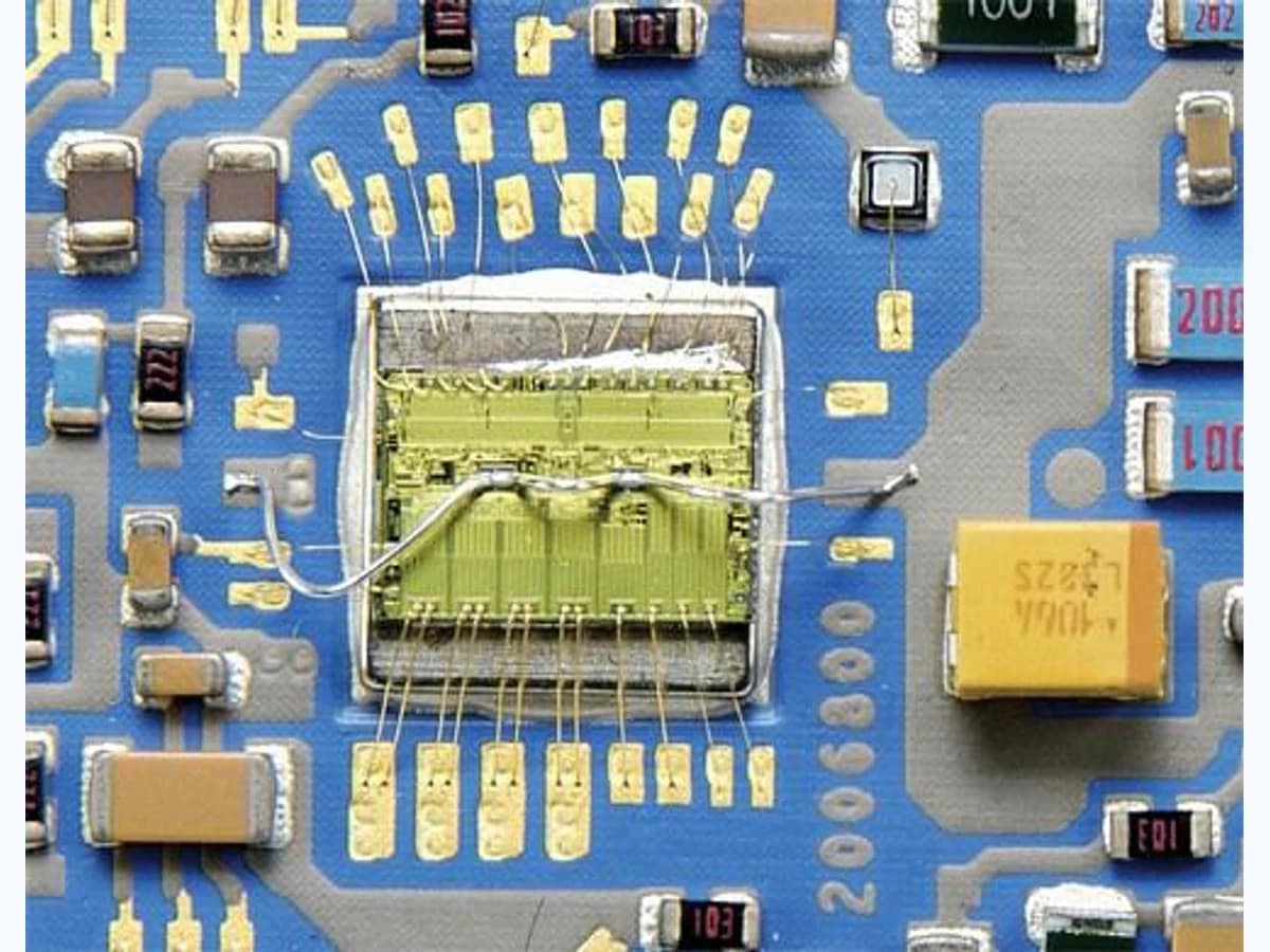 Real macro product photograph of a hybrid ceramic circuit with a die and fine wire bonds