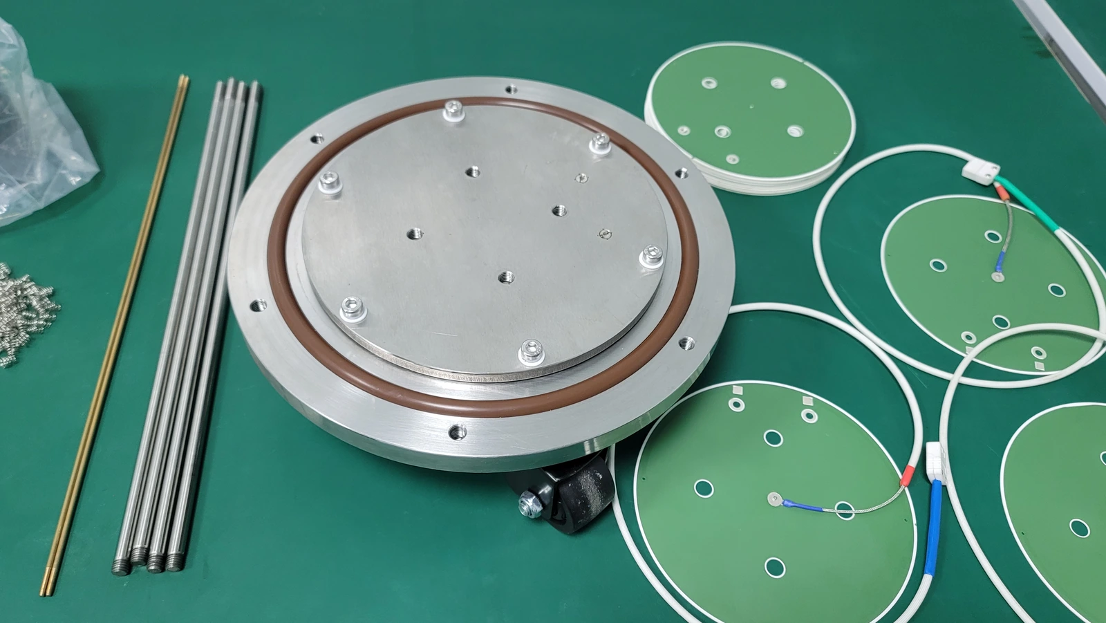 Heater elements and metal fixture components arranged together on a work surface.