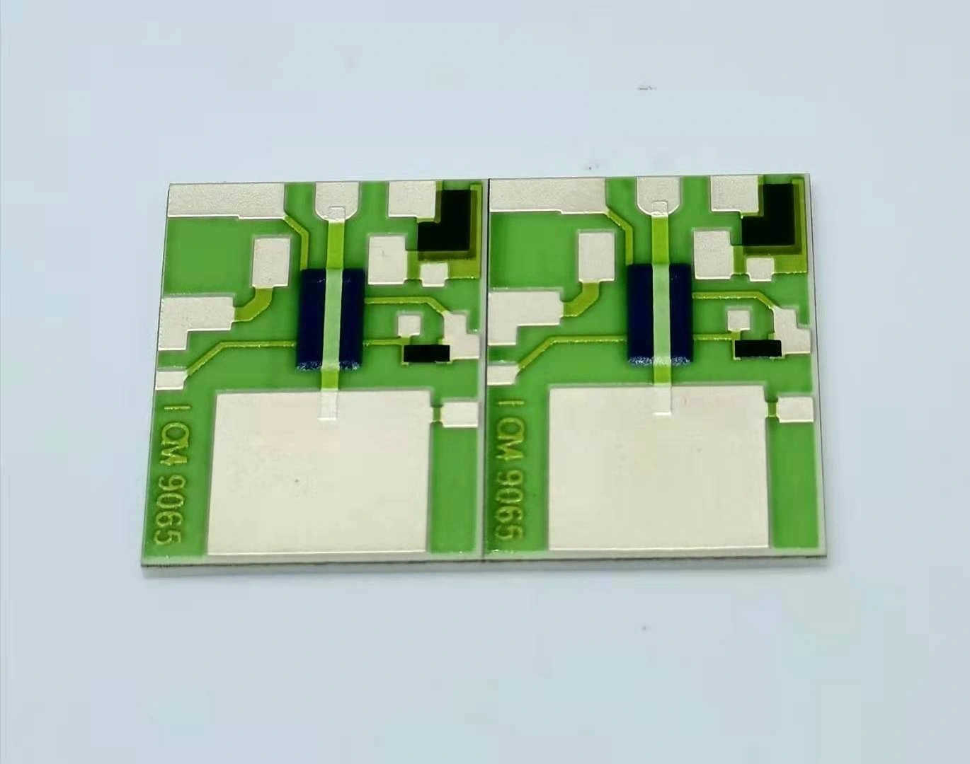 Two joined ceramic circuit units with green overglaze, exposed pads and blue dielectric features.