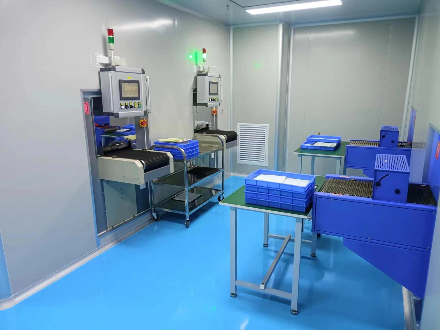 Conveyor thermal-processing stations with ceramic-part trays and transfer trolleys in a workshop.