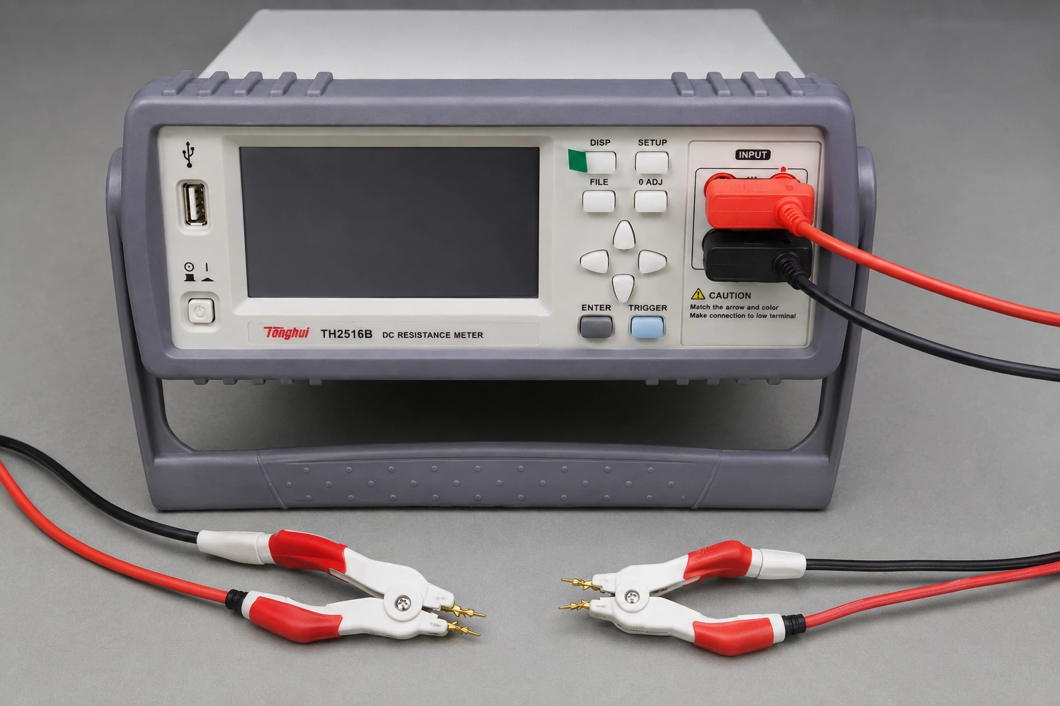 A resistance meter with its display off beside two open Kelvin clips before coupon connection.