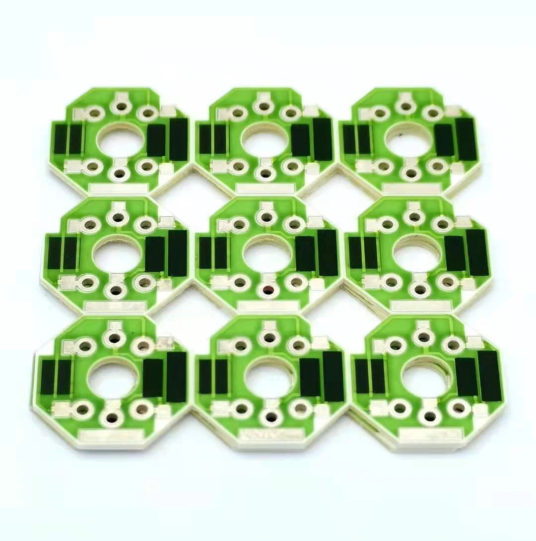 Nine ceramic resistor units with green protective glaze, central apertures and exposed connection holes.