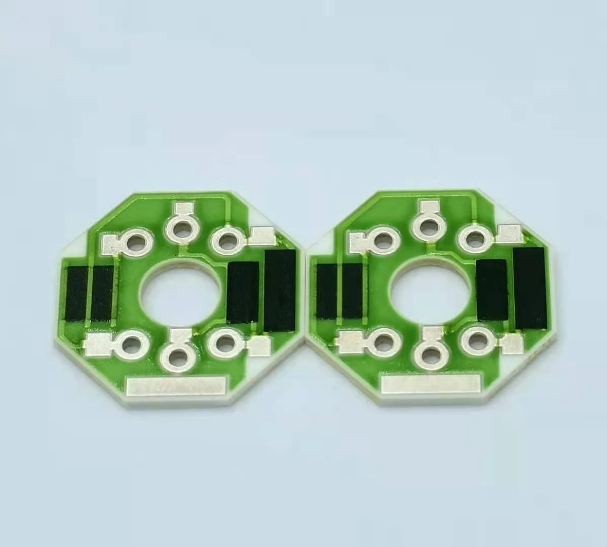 Two joined ceramic resistor units with central openings, green protection and black resistive features.