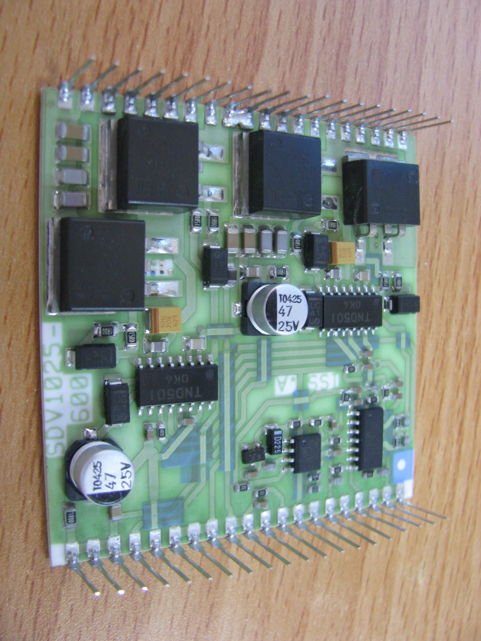 An assembled hybrid circuit with attached electronic components and long external connection pins.