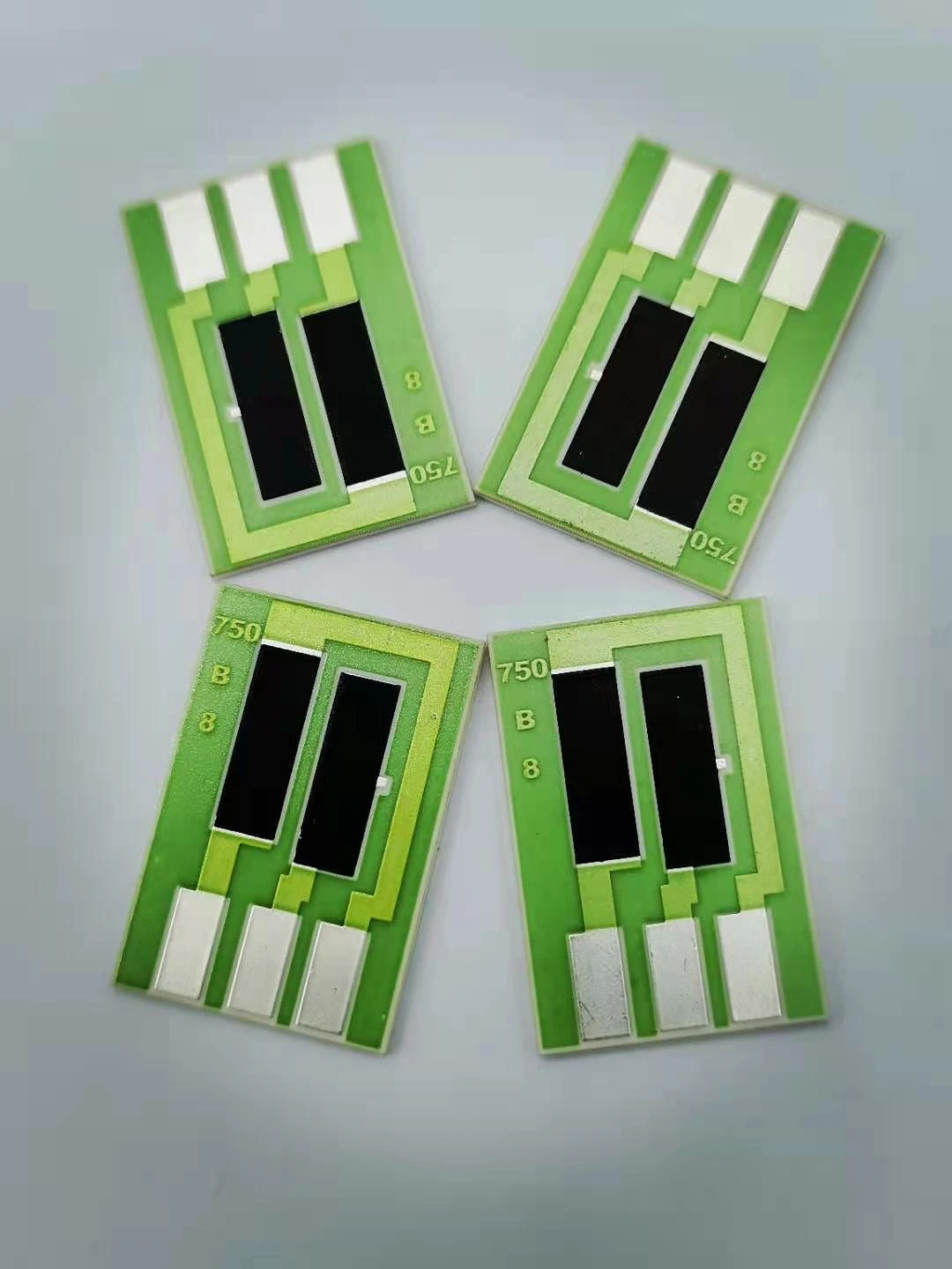 Four ceramic resistor parts with black resistive films, green protective glass and exposed terminal pads.