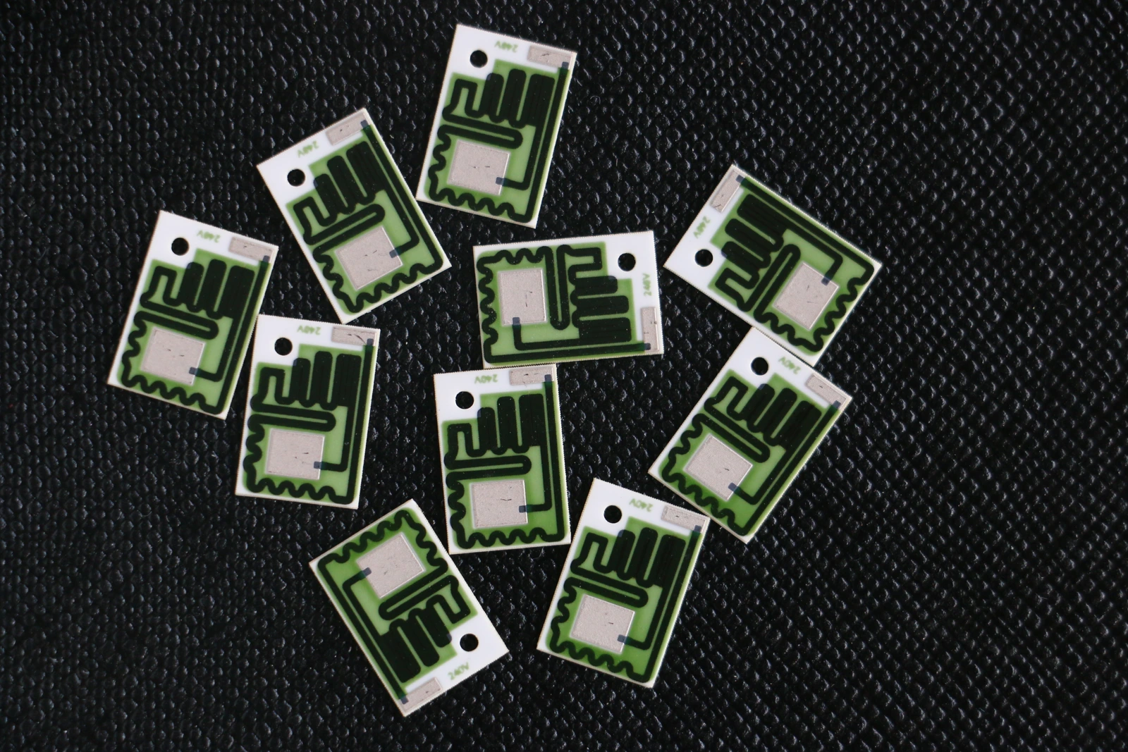 Small ceramic resistor circuits with varied black printed paths, green protective regions and exposed pads.