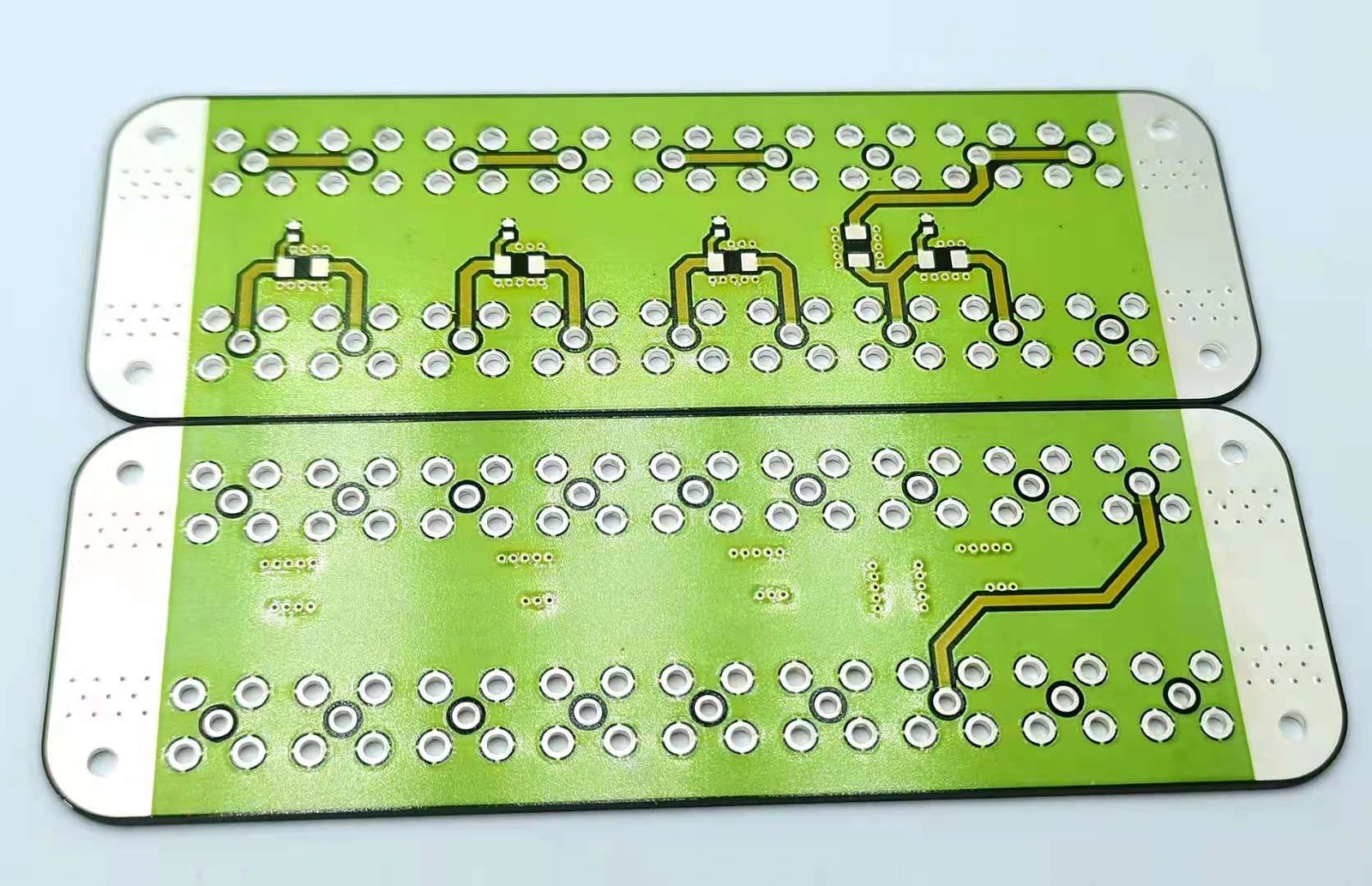 Elongated green-protected ceramic circuits with rounded corners, contact holes and exposed metal regions.