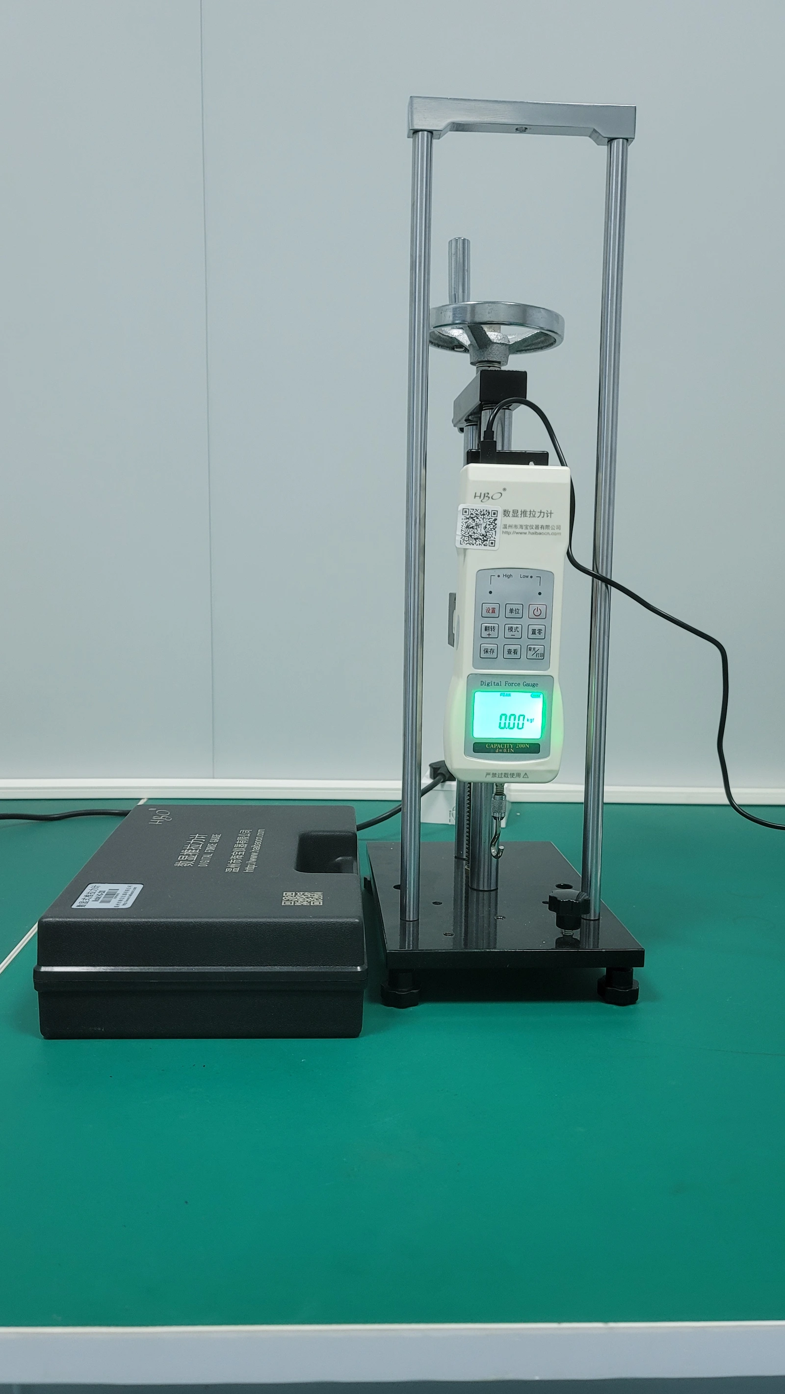 A vertical force-test stand with a loading column, gauge and specimen attachment region.
