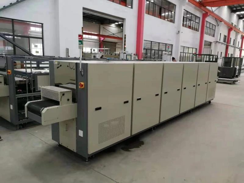 A long conveyor furnace with loading and unloading sections in a production area.