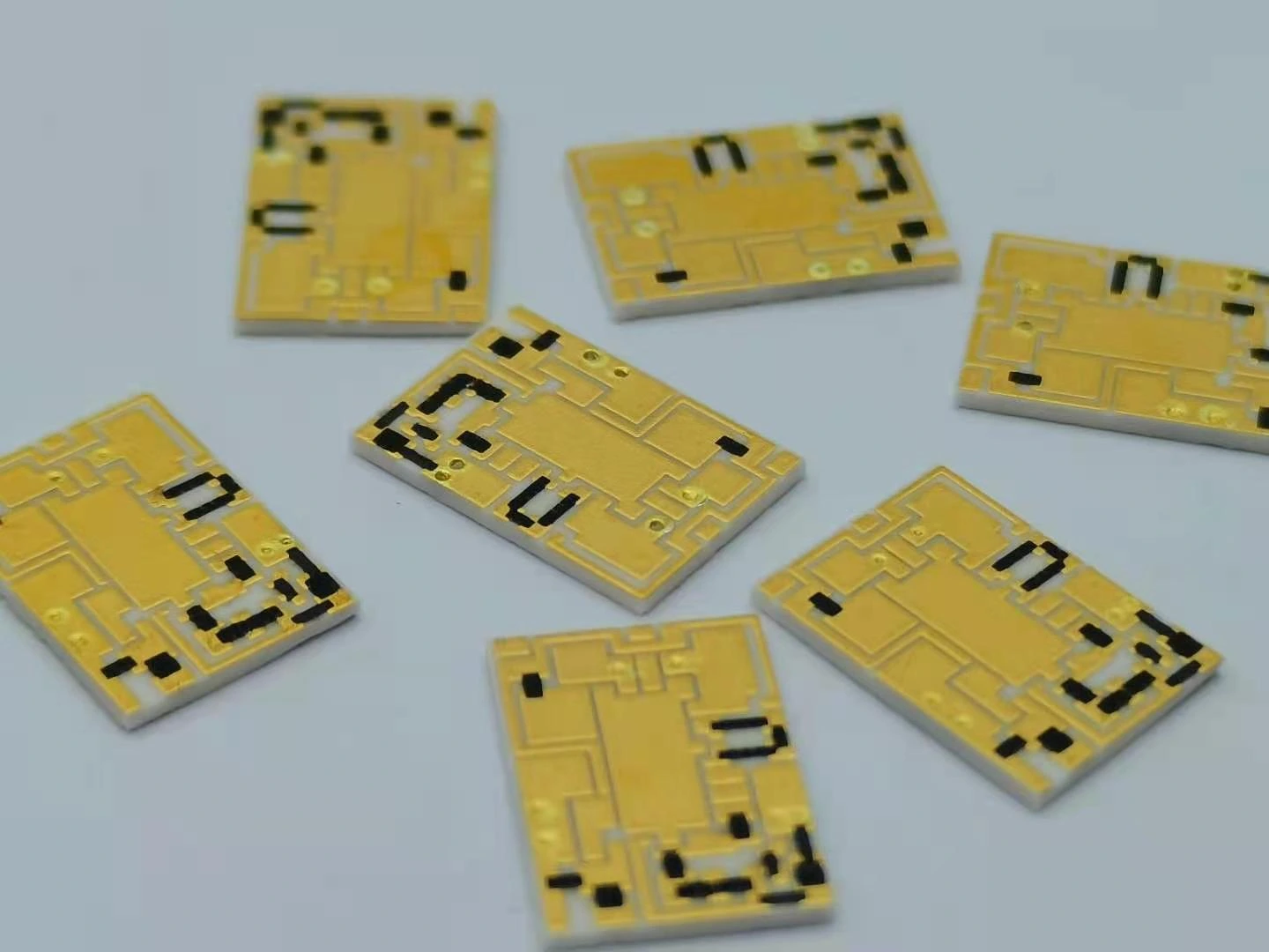 Several printed circuits with gold-coloured routing, exposed pads and black resistive regions.