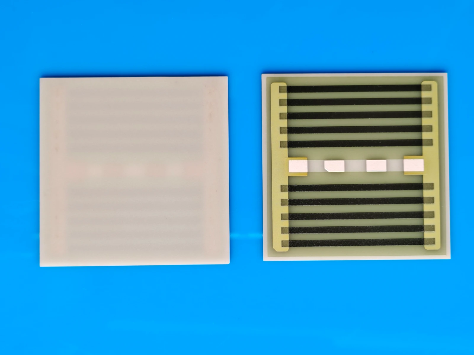 Front and reverse views of a rectangular heater plate with repeated resistive strips and exposed terminal regions.