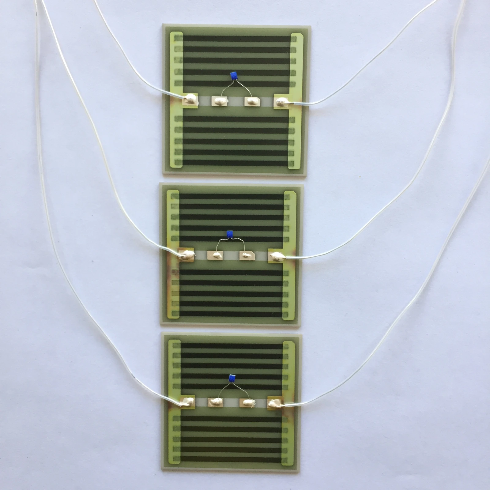 Two rectangular heater elements with white leads and small attached sensing components.