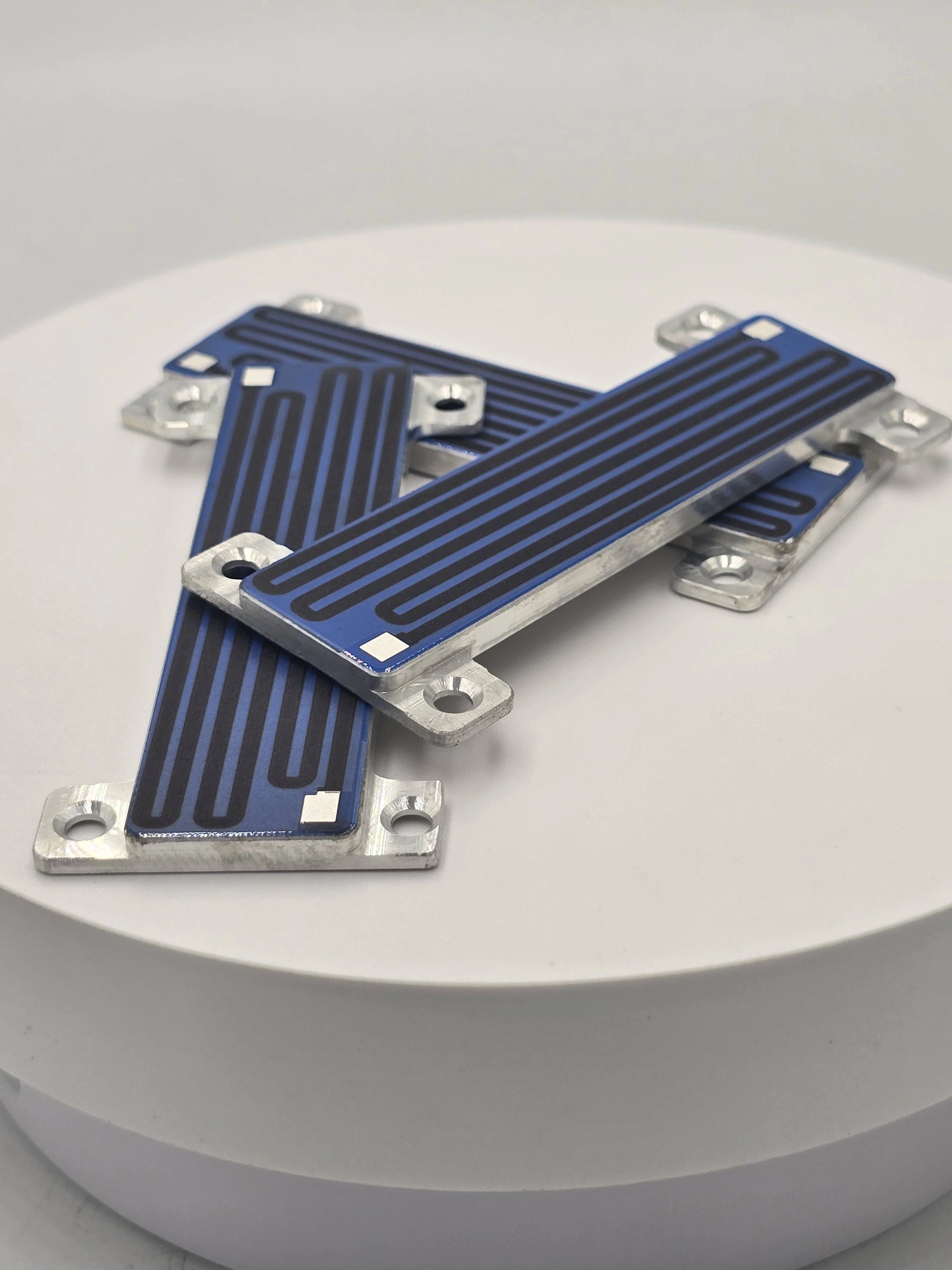 A group of elongated blue-coated heater strips with exposed terminal areas and metal mounting ends.