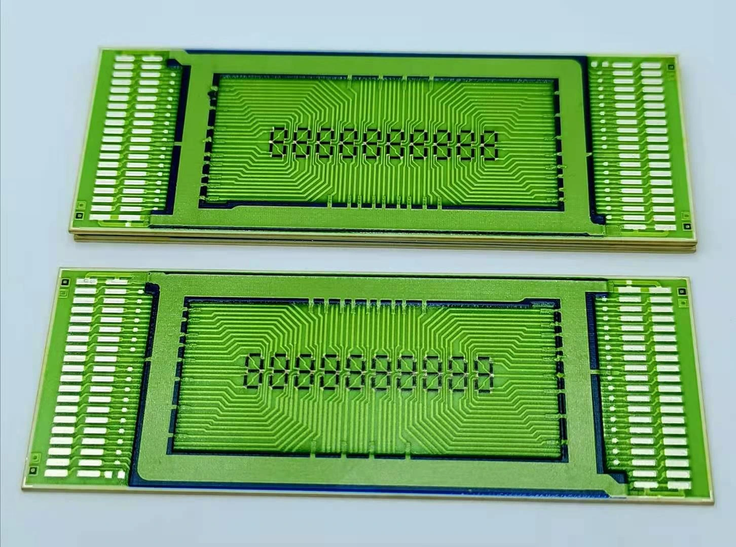 Two rectangular printed circuit units with repeated connection paths and long edge contact rows.