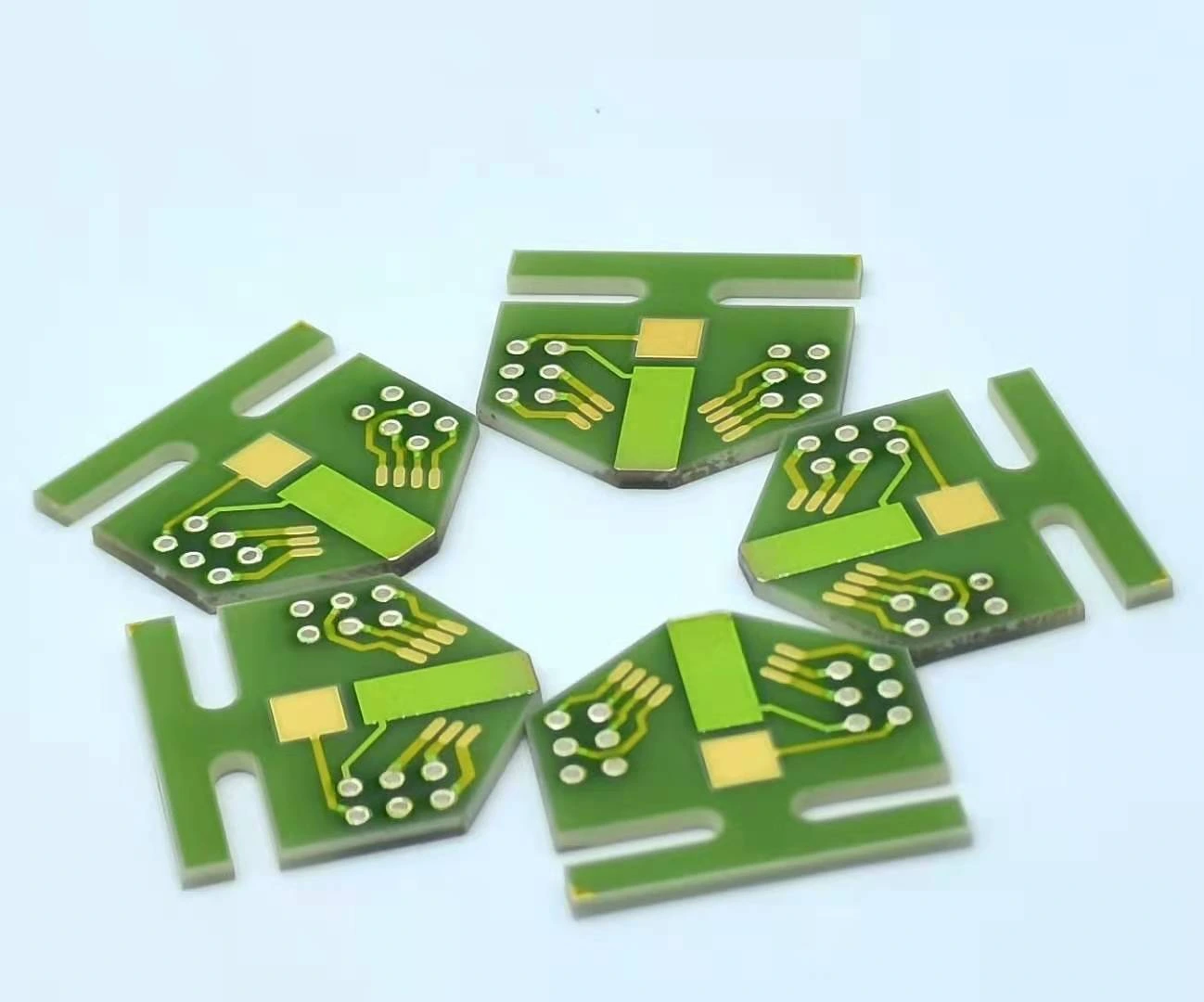 Slotted ceramic circuits with exposed gold-coloured pads, mounting cut-outs and patterned conductors.