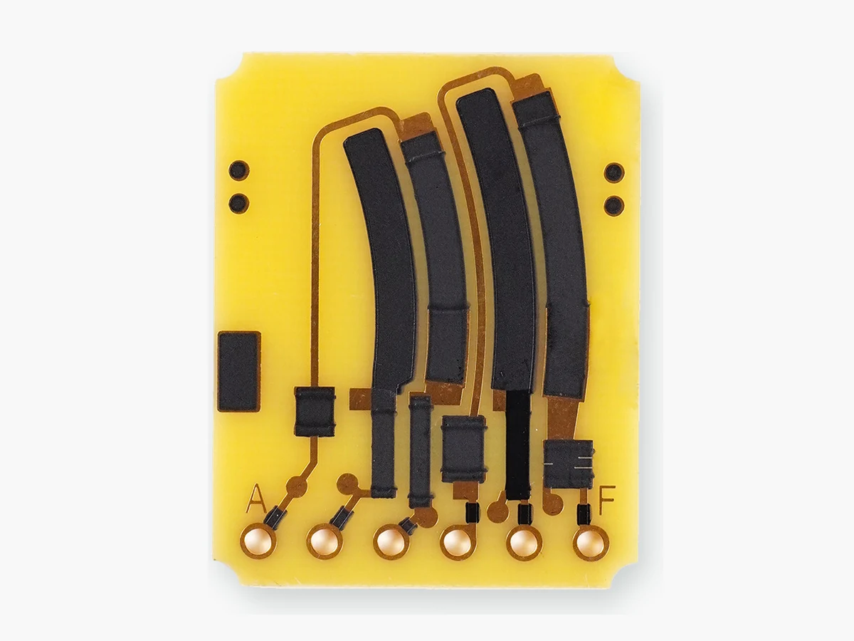 Source-derived front view of the supplied rigid yellow board with curved black printed regions, conductor paths, terminal holes, and A/F markings