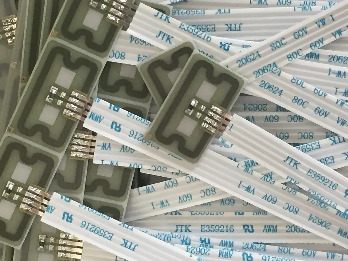 Real flexible sensor samples with printed tracks and attached cable tails