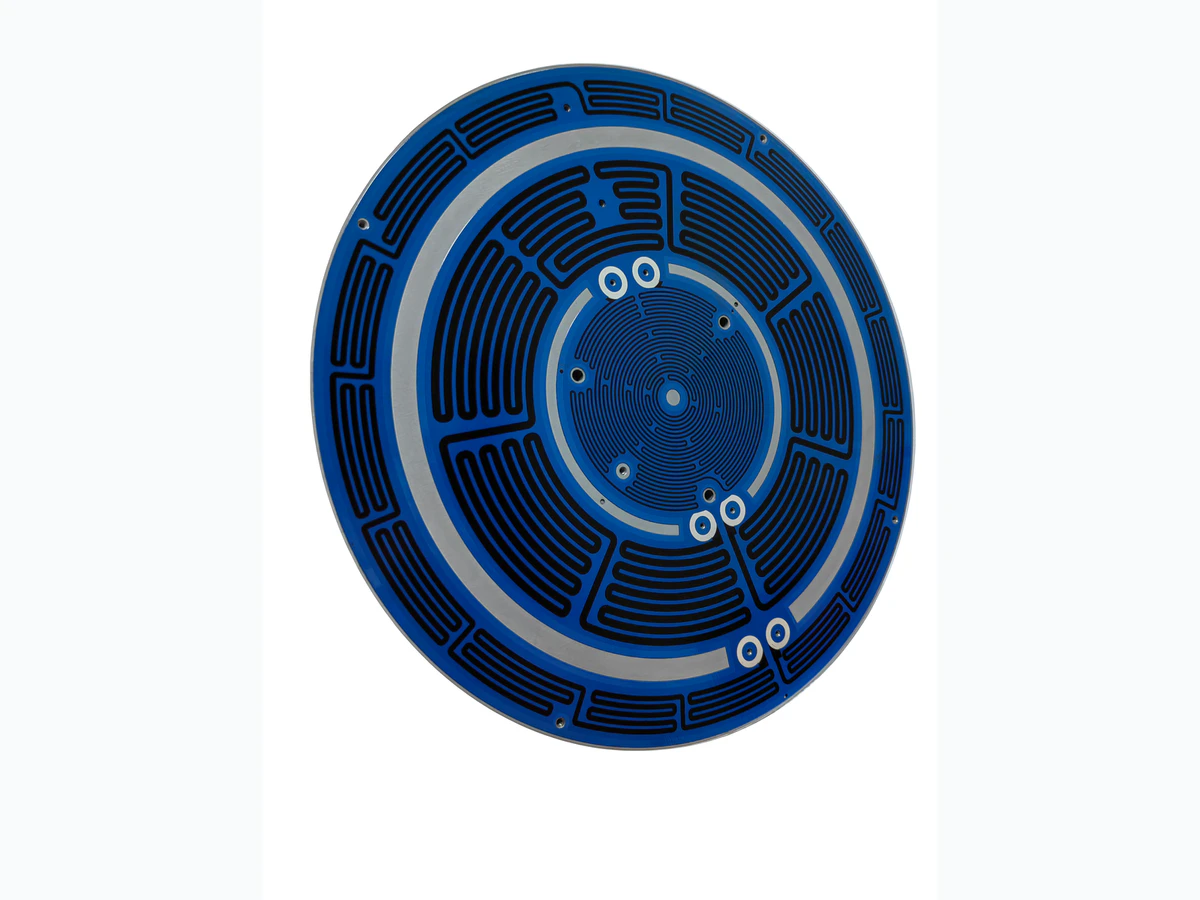 Supplied aluminum substrate heater photograph showing a circular printed layout and mounting features