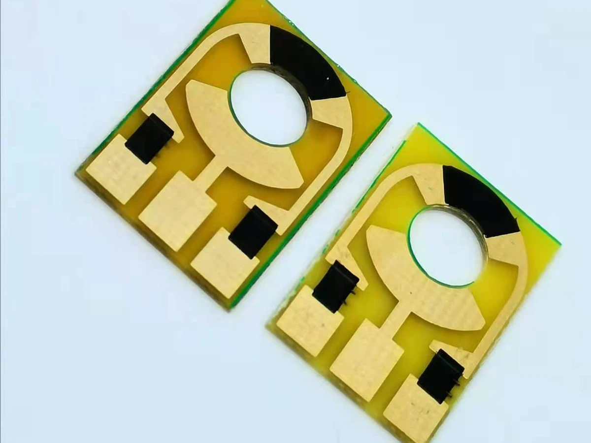 Controlled detail crop of a verified carbon contact PCB showing black contact material beside exposed conductor areas