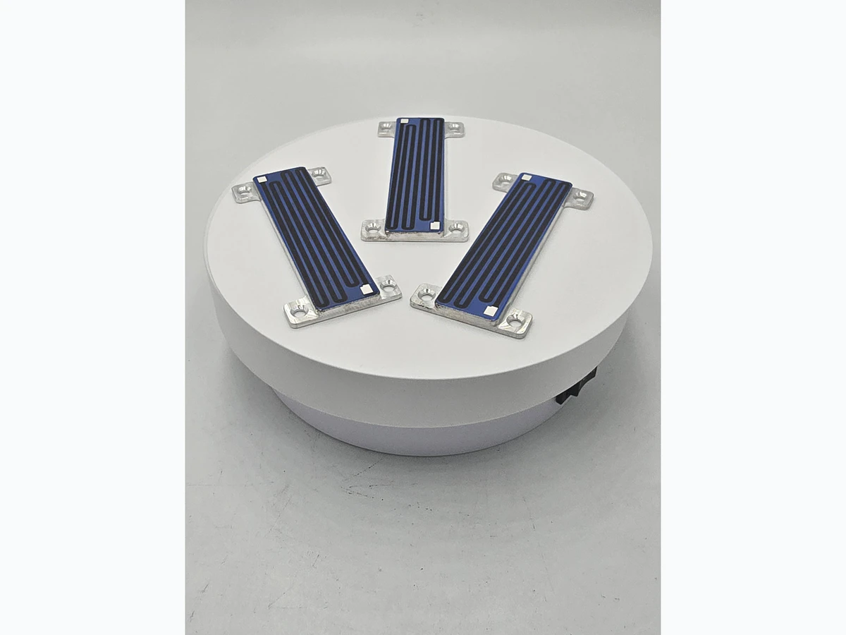 Group of compact heater modules showing visible outlines, mounting ears, holes, and printed surfaces