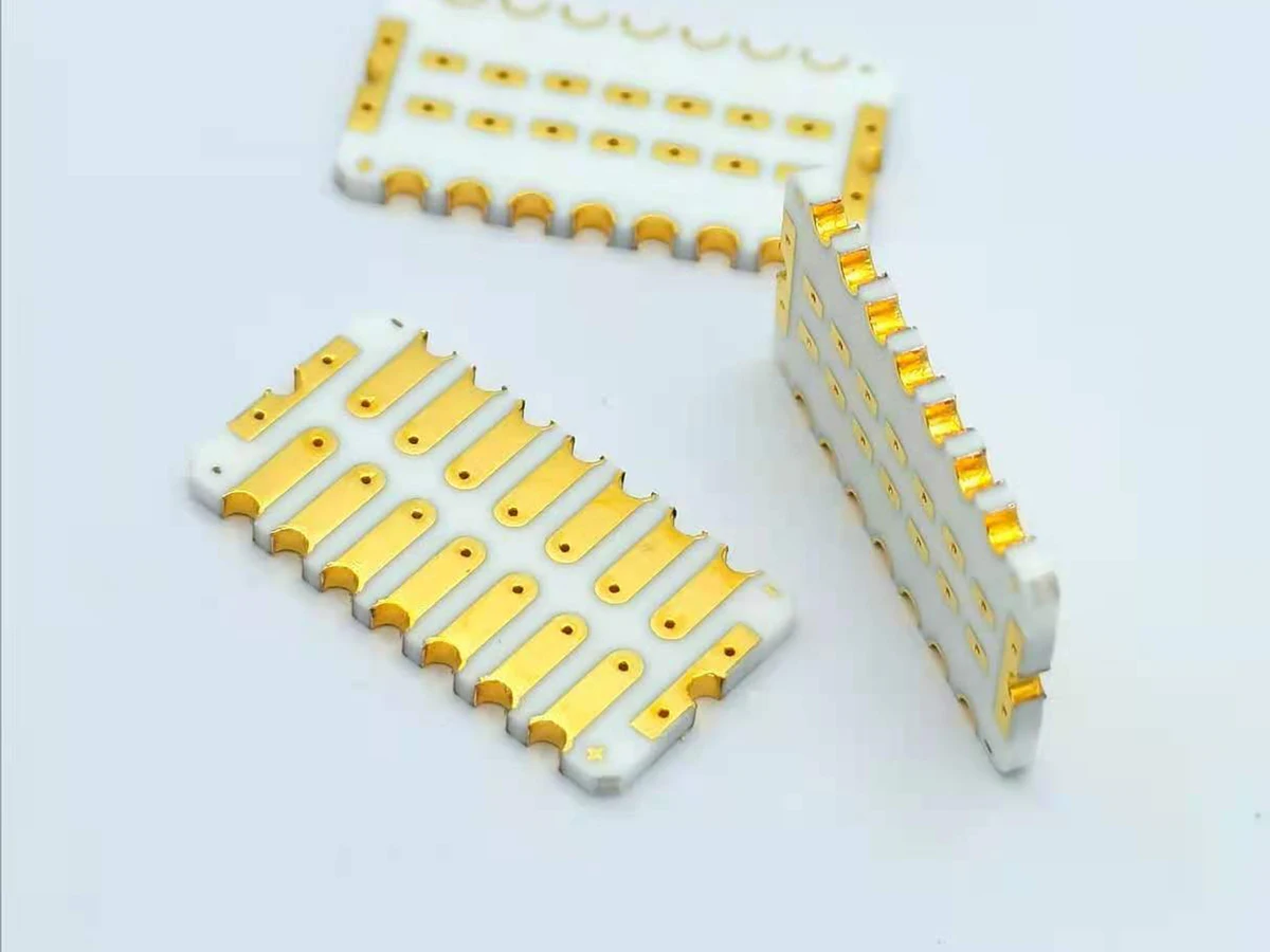 Controlled detail crop of a verified double-sided gold-colored ceramic PCB showing pads, rails, holes, and edge features
