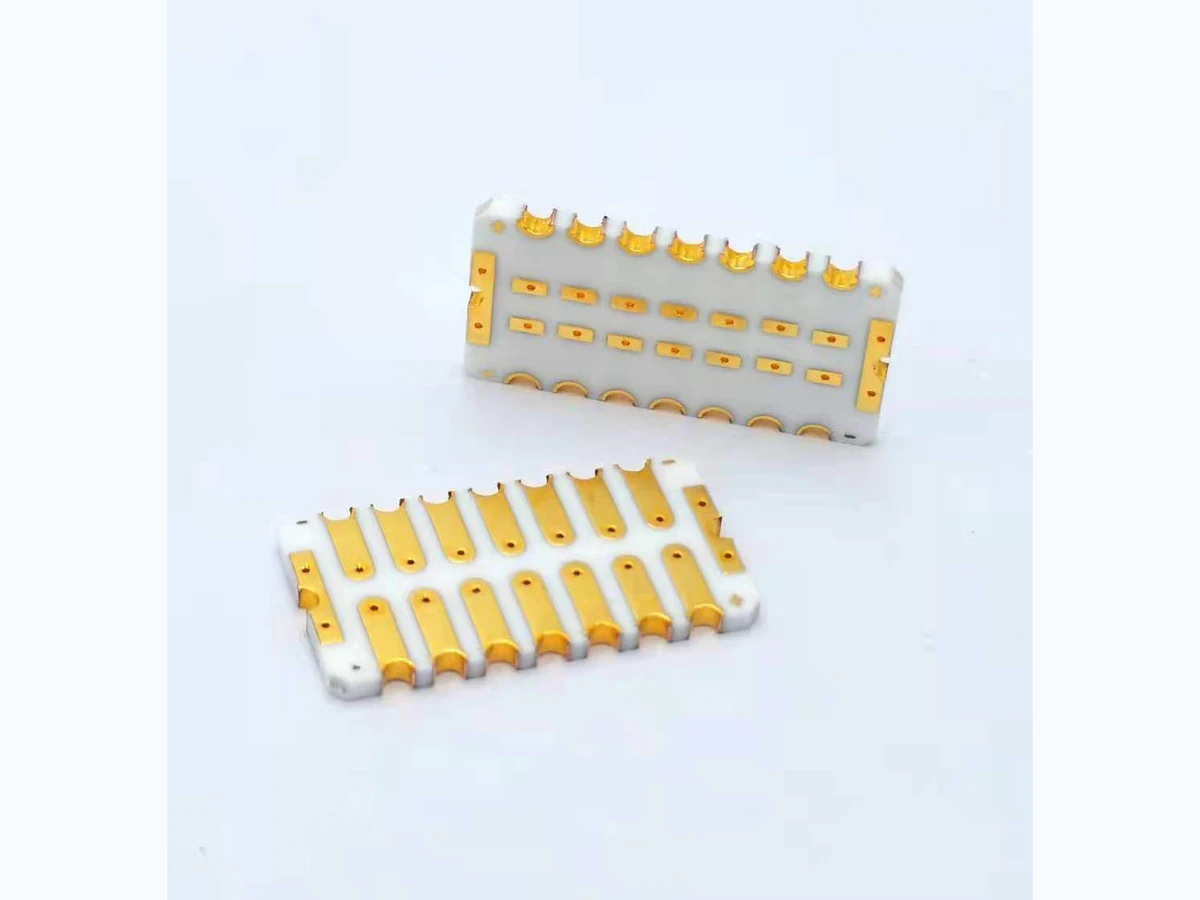 Double-sided gold-colored ceramic PCBs with white ceramic bodies, patterned pads, holes, and scalloped edge features
