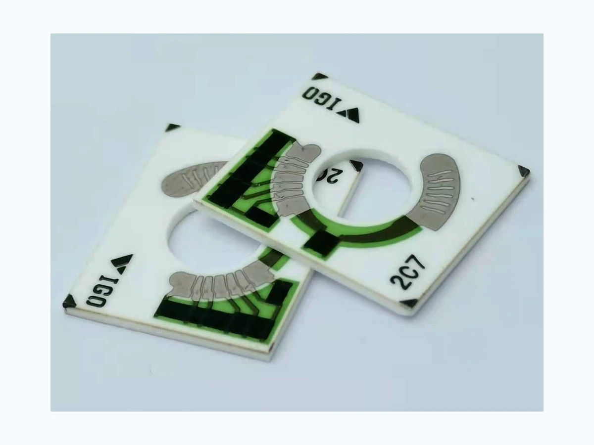 Two complete motorcycle fuel gauge resistor cards with central openings and arc tracks