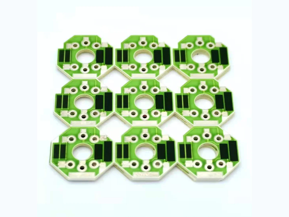 Nine octagonal green ceramic thick film voltage dividers with paired black resistor regions and circular center openings
